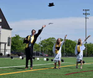 Lincoln Academy students from science teacher Matthew Buchwalder's advisory group toss their graduation caps in the air during a physically distant commencement ceremony on the William A. Clark Field in Newcastle on June 5. (Evan Houk photo)