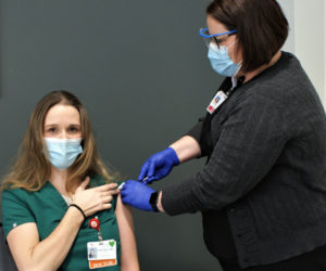 Dr. Leah Elias, a physician in the emergency department at LincolnHealth's Miles Campus in Damariscotta, receives a COVID-19 vaccine from Sara White on Tuesday, Dec. 22. Elias was among the first LincolnHealth caregivers to receive the vaccine. (Photo courtesy John A. Martins/LincolnHealth)