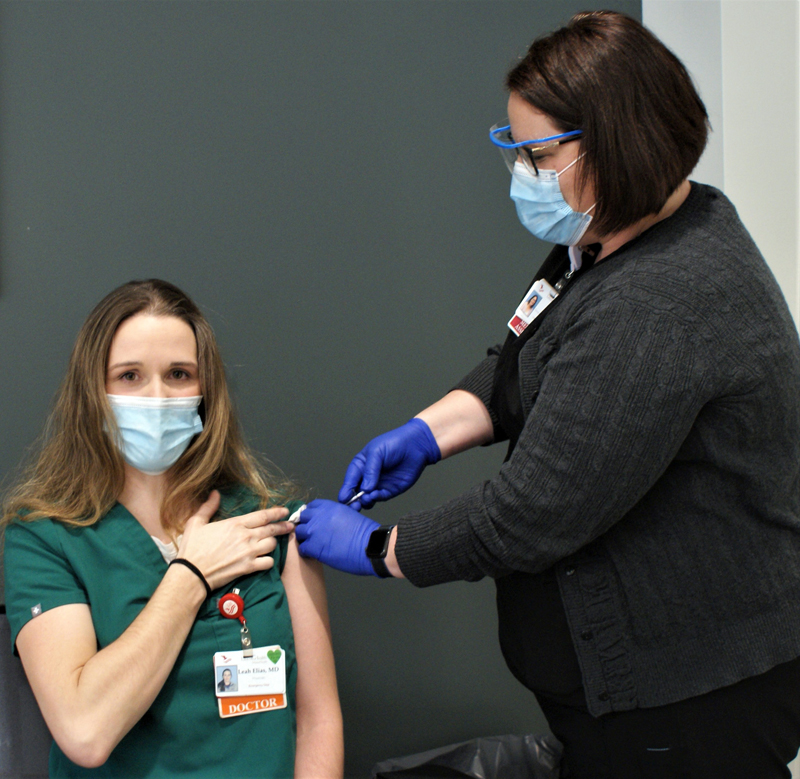 Dr. Leah Elias, a physician in the emergency department at LincolnHealth's Miles Campus in Damariscotta, receives a COVID-19 vaccine from Sara White on Tuesday, Dec. 22. Elias was among the first LincolnHealth caregivers to receive the vaccine. (Photo courtesy John A. Martins/LincolnHealth)