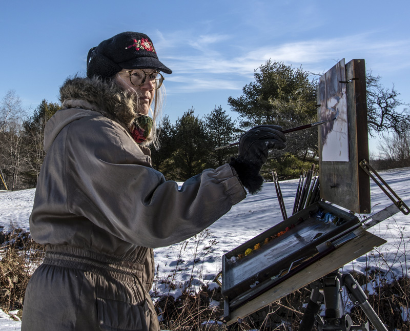 Roberta Goschke paints a wintry scene in Waldoboro on Sunday, Jan. 10. Goschke "suits up" for plein-air painting sessions in winter. (Bisi Cameron Yee photo)