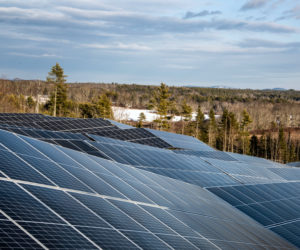 Solar panels work with the topography of the site at the SunRaise solar garden in Waldoboro on Dec. 22. Metal rods tipped with screws are driven 4 feet into the granite ledge to stabilize the large panels. (Bisi Cameron Yee photo)
