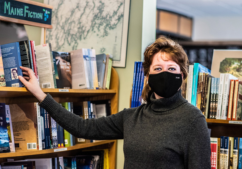 Chloe Deblois adjusts the placement of a book at Sherman's Maine Coast Book Shop in Damariscotta on Sunday, Feb. 21. Deblois has worked for the store for 12 years and managed it for the last five. (Bisi Cameron Yee photo)