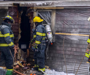 Firefighters inspect the wall of a Nobleboro farmhouse after extinguishing a fire there Sunday, Feb. 7. An improperly installed pellet stove caused the fire, according to a Nobleboro Fire Department officer. (Photo courtesy Nobleboro Fire Department)