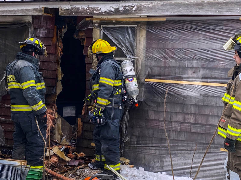 Firefighters inspect the wall of a Nobleboro farmhouse after extinguishing a fire there Sunday, Feb. 7. An improperly installed pellet stove caused the fire, according to a Nobleboro Fire Department officer. (Photo courtesy Nobleboro Fire Department)