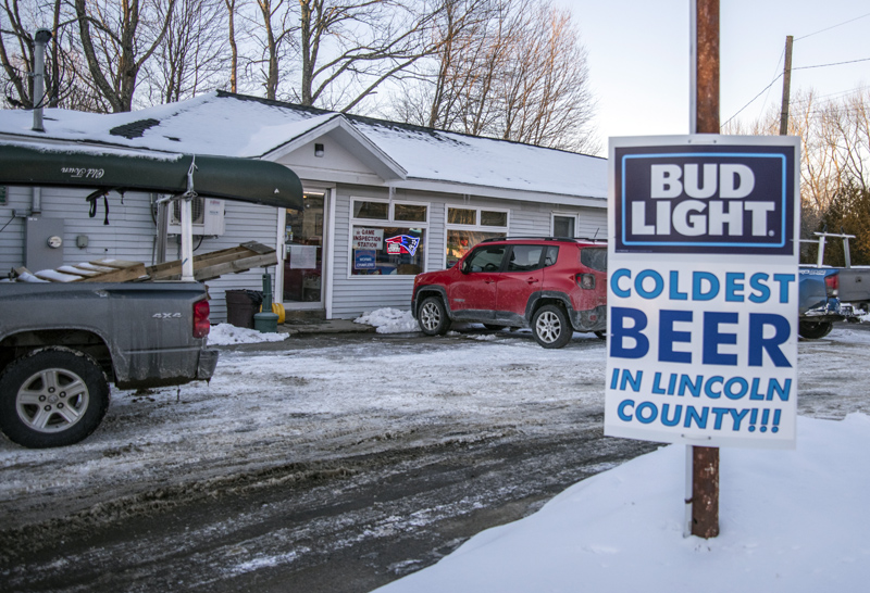 A sign advertises the "coldest beer in Lincoln County" at the Nobleboro Village Store on Monday, Feb. 8. The state temporarily closed the store, citing a failure to enforce mask-wearing. (Bisi Cameron Yee photo)