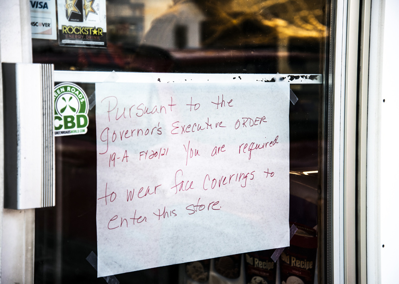 A handmade sign on the door of the Nobleboro Village Store alerts customers to the state's mask-wearing requirement on Monday, Feb. 8. (Bisi Cameron Yee photo)