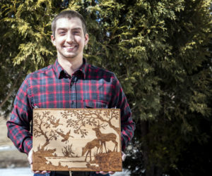 Tyler Richards displays an example of his woodburning technique on a cutting board in Damariscotta on Monday, March 8. Richards learned woodburning through trial and error and YouTube. (Bisi Cameron Yee photo)