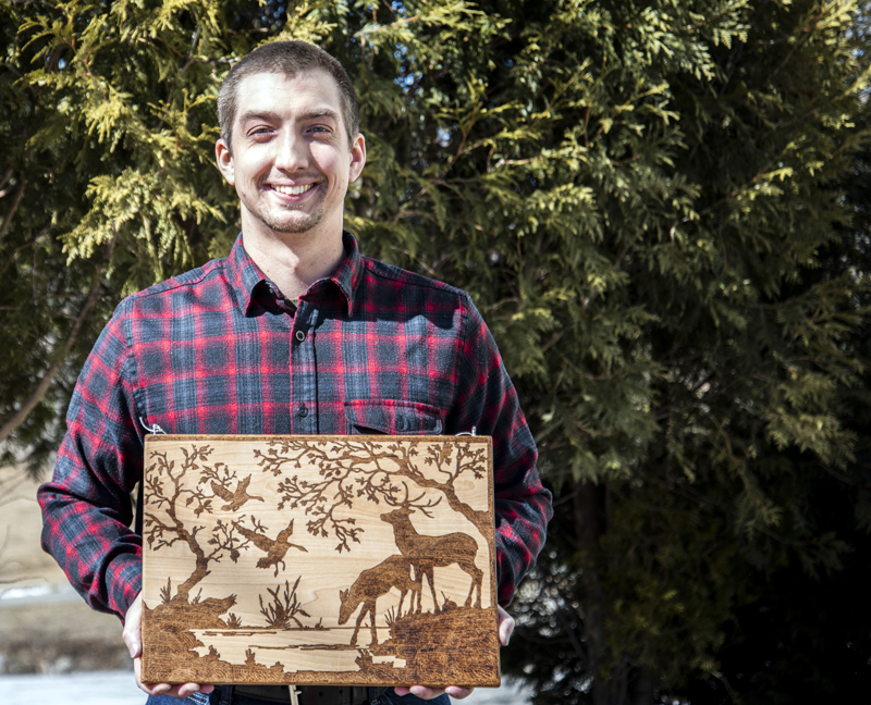 Tyler Richards displays an example of his woodburning technique on a cutting board in Damariscotta on Monday, March 8. Richards learned woodburning through trial and error and YouTube. (Bisi Cameron Yee photo)