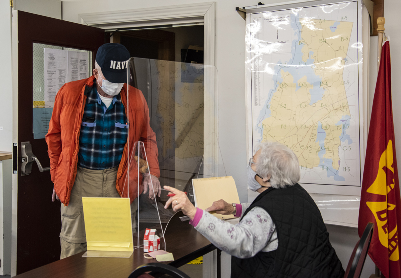 Bob Nelson receives his ballot from Nancy Hartford in Nobleboro on Friday, March 19. Nelson was among the first voters to arrive at the polls for the annual town meeting by referendum. (Bisi Cameron Yee photo)