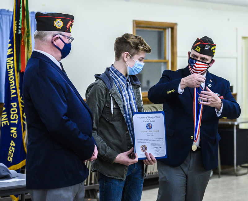 E.J. Hunt (center) receives a medal from Veterans of Foreign Wars State Cmdr. Michael "Keith" Davis (left) and Patriot's Pen Chair Anthony Kimble at the VFW post in Waldoboro on Thursday, March 11. (Bisi Cameron Yee photo)