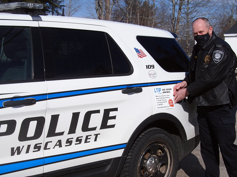 Sgt. Perry Hatch of Wiscasset Police Department places a new LTIP decal on his cruiser.