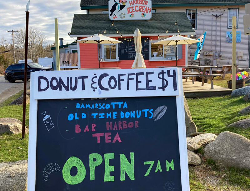 A sign advertises local food and drink at Harbor Ice Cream and Cafe on the Hill, Tuesday, April 6. The business opened for the season Saturday, April 3. (Nettie Hoagland photo)