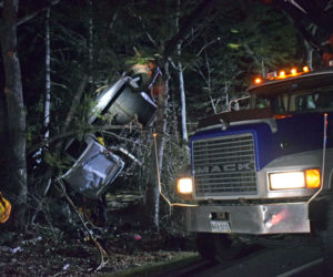 A pulp truck operated by Joe Winchenbach works to free a pickup truck from trees off Bristol Road near Pemaquid Falls late Tuesday, April 13. (Evan Houk photo)