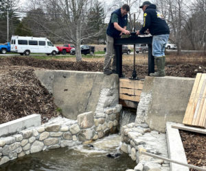 Bristol Board of Selectmen Chair Chad Hanna (left) and Bristol Fish Committee member Rick Poland open the head gate to allow water to flow into the new Bristol Mills fish ladder for the first time on Sunday, April 18. (Evan Houk photo)