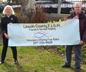 Terri Taylor (left) and Edie Vaughan hold a banner for Lincoln County Friends in Service Helping, also known as LC FISH. Vaughan has stepped down as the head of the program, which Taylor will now lead.