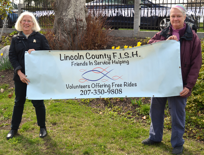 Terri Taylor (left) and Edie Vaughan hold a banner for Lincoln County Friends in Service Helping, also known as LC FISH. Vaughan has stepped down as the head of the program, which Taylor will now lead.
