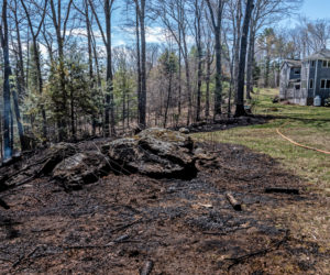 Charred land where a woods fire encroached on a yard in Somerville on Tuesday, April 27. The fire came within 100 feet of the house. (Bisi Cameron Yee photo)