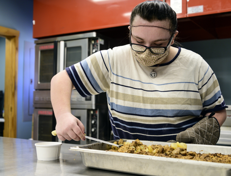 Kiara Luce scoops out a serving of apple crisp in Whitefield on Wednesday, April 14. The remainder of the tray was served to Luce's class for breakfast the next day. (Bisi Cameron Yee photo)