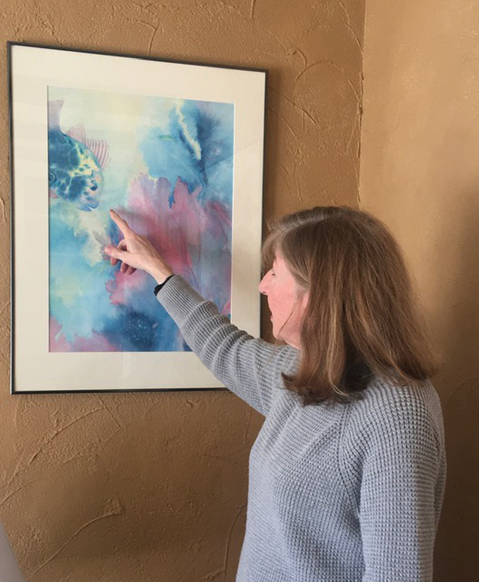 Hilary Bartlett points to her painting "Sea Fantasy."