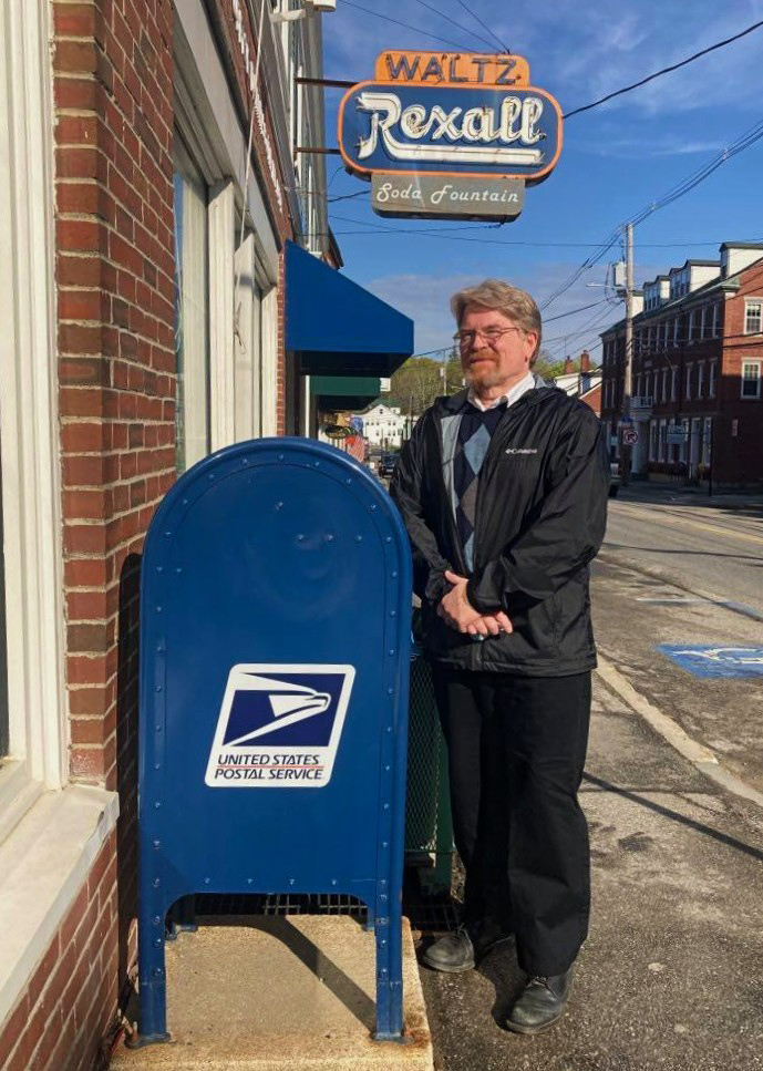 Recently retired Damariscotta Postmaster Tom Hutchins stands outside his office for the last 16 years. (Nettie Hoagland photo)