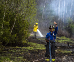 A firefighter gives a thumbs-up to start pumping water during a brush fire in Jefferson on Monday, May 3. (Bisi Cameron Yee photo)