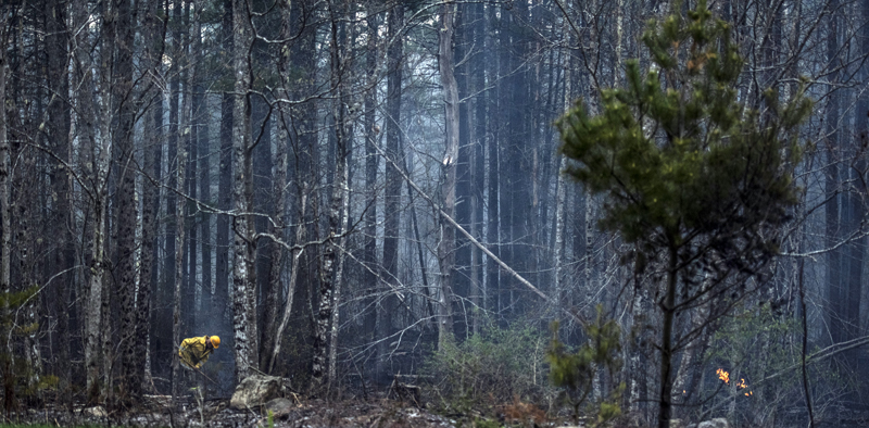 A firefighter moves through a woods fire in Jefferson on Monday, May 3. (Bisi Cameron Yee photo)