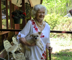 Bette Monfort holds the Boston Post Cane and her 10-year-old dog, Candy, at her home on Westport Island, Friday, May 21. The cane honors Monfort as the town's eldest resident. (Charlotte Boynton photo)