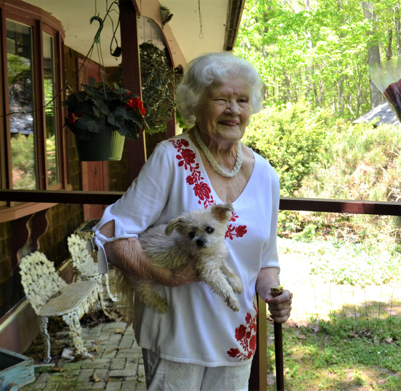 Bette Monfort holds the Boston Post Cane and her 10-year-old dog, Candy, at her home on Westport Island, Friday, May 21. The cane honors Monfort as the town's eldest resident. (Charlotte Boynton photo)