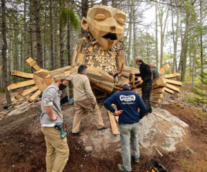 A crew from Bristol Marine assists with the installation of a giant troll at Coastal Maine Botanical Gardens.