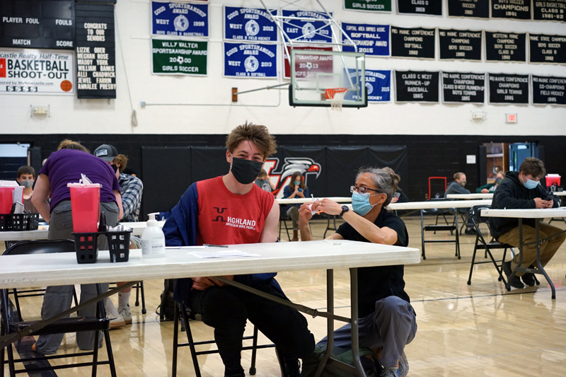 Lincoln Academy ninth grader Jonas Stepanauskas gets vaccinated by LincolnHealth registered nurse Angela Russ at the LA vaccination clinic on Tuesday, May 18.