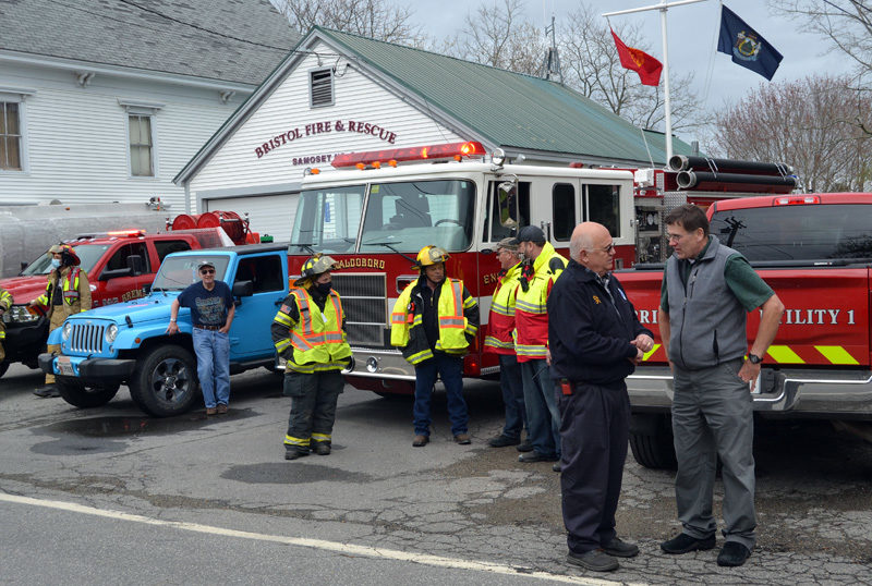 Bristol Fire Chief Paul Leeman Jr. (second from right) talks with Bristol Board of Selectmen Chair Chad Hanna outside the Round Pond fire station on Friday, April 30. Firefighters from around the county gathered in the village to mark Leeman's retirement as chief. (Maia Zewert photo)