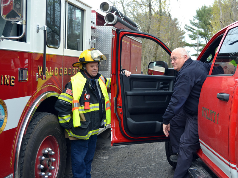 Waldoboro firefighter Billy Bragg holds the door for Bristol Fire Chief Paul Leeman Jr. as he arrives at the Round Pond fire station on Friday, April 30. (Maia Zewert photo)