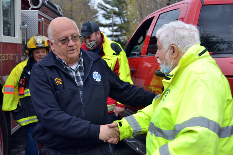 Bristol Fire Chief Paul Leeman Jr. (left) shakes hands with Bremen Selectman Hank Nevins in Round Pond on Friday, April 30. (Maia Zewert photo)
