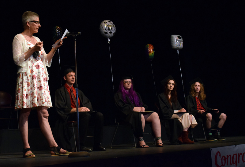 Central Lincoln County Adult Education instructor Elizabeth Potter reads a poem by Edgar Guest about perseverance, “It Couldn’t Be Done,” before toasting to the 2020-2021 graduates of the program during a ceremony at the Lincoln Theater on Tuesday, June 8. From left: Elizabeth Potter, Zachary Baker, Emmalie Blanchard, Honora Boothby, and Norbert Ferrero. (Evan Houk photo)