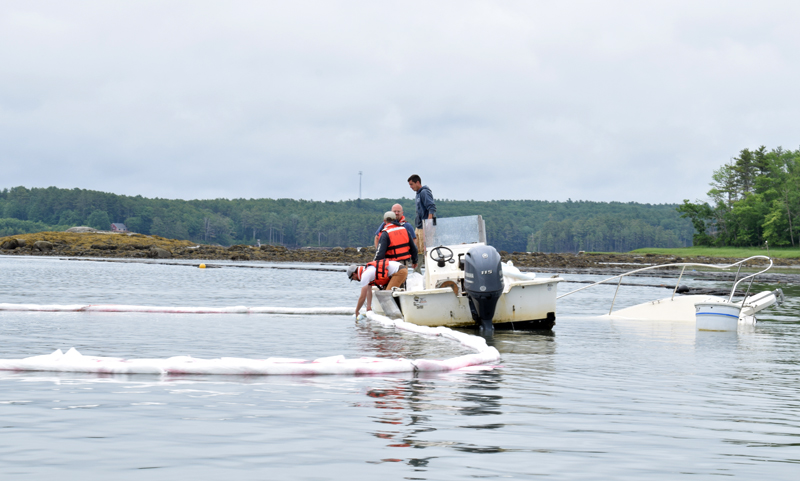Newcastle and Damariscotta firefighters work to contain a diesel fuel spill from an approximately 26-foot long sunken boat in the Damariscotta River in Newcastle on the morning of Friday, June 25. The spill was located about 100 feet from a nearby Norumbega Oyster, Inc. farm. (Evan Houk photo)