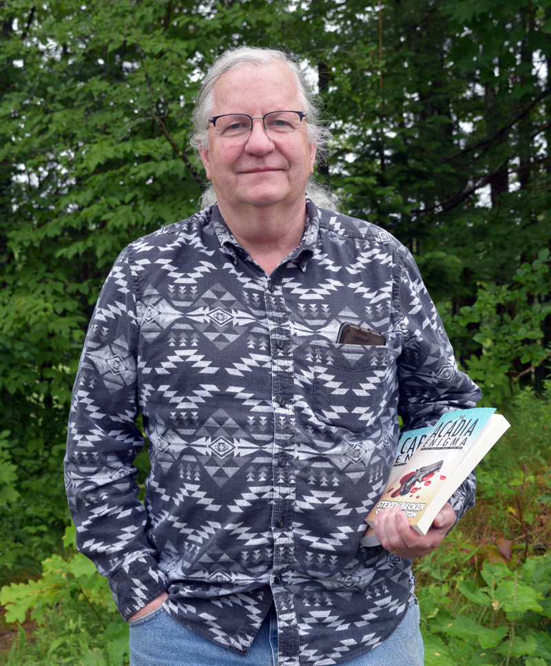 Nobleboro resident Chuck Benton holds his two books, "The Acadia Enigma" and "The Cape Cod Enigma." Benton began writing with his bestselling co-author, Steven Becker, in 2020. (Nate Poole photo)