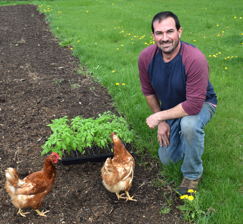 Josh Hatch poses in his garden with the chickens that he raises on his property in Nobleboro on May 6. Hatch did not seek reelection to the Nobleboro School Committee this year after 15 consecutive years of service. (Evan Houk photo)