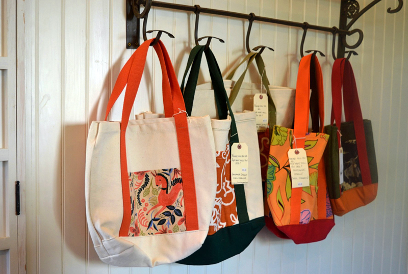 Carol Hoagland, of Bristol, sells her handmade canvas and leather bags at Kneaded Provisions on Rutherford Island. Manager Jennifer Keegan encourages local artists and artisans to display and sell their work at the business. (Nettie Hoagland photo)