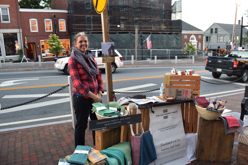 Hilary Crowell stands at her table at the Wiscasset Art Walk on Thursday, June 24. Crowell owns The Cultivated Thread, a Midcoast handwoven goods business in Bath. (Nate Poole photo)