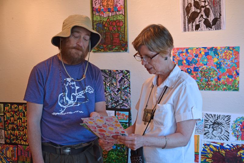 Visiting artist Seth Bond Perry (left) and Wiscasset Art Walk co-founder Lucia Droby discussing some of Perry's work in the Hasenfus Gallery on Thursday, June 24. (Nate Poole photo)