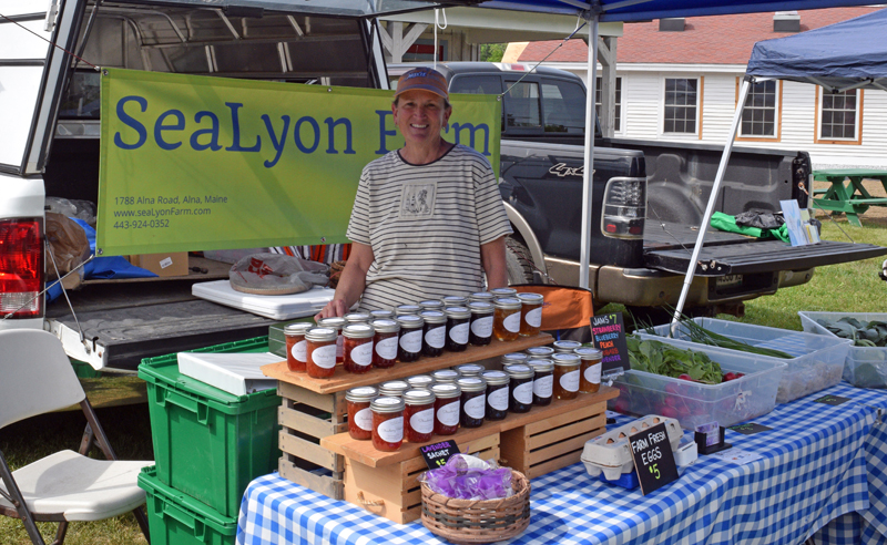 Marcia Lyons, president of the Wiscasset Farmers' Market, stands in her tent at the market on Wednesday, June 2. Lyons co-owns SeaLyon Farm, of Alna, with her husband Don. (Nate Poole photo)