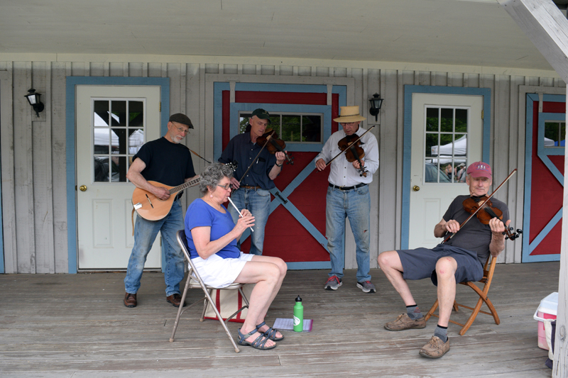 Folk musicians perform on the front porch of the Maine Tasting Center at the Wiscasset Farmers' Market on Wednesday, June 2. (Nate Poole photo)