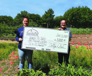 From left: Olivia Poole, of Colby & Gale Inc., presents a check for $1,000 to Erica Berman, of Veggies to Table.