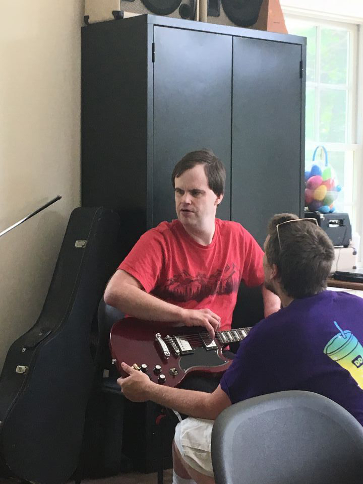 Brandon participates in a music class with a Mobius staff member.