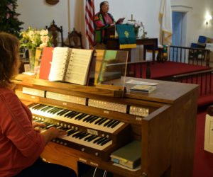 Organist Tricia Demers plays a hymn as Pastor Kelly Harvell leads the congregation in song during the final service of the Round Pond United Methodist Church on Sunday, June 27. About 43 people ended to celebrate and reflect on the church's 168-year history. (Evan Houk photo)