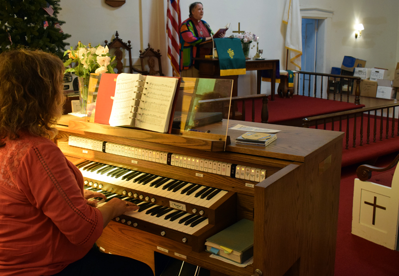 Organist Tricia Demers plays a hymn as Pastor Kelly Harvell leads the congregation in song during the final service of the Round Pond United Methodist Church on Sunday, June 27. About 43 people ended to celebrate and reflect on the church's 168-year history. (Evan Houk photo)