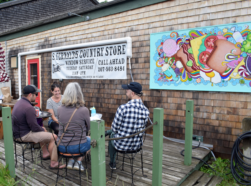 Diners enjoy a meal outside of S. Fernald's Country Store in Damariscotta on Friday, June 25. The store reopened to walk-in traffic on Tuesday, June 22, and sandwiches will continue to be available by window service on the opposite end of the building. (Evan Houk photo)