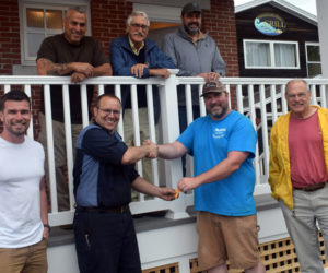 Robert Mattes, of Rockport-based Phi Builders + Architects, hands over the keys for the newly completed Damariscotta public restrooms to Damariscotta Board of Selectmen Chair Daryl Fraser on Friday, July 2. Front row, from left: Tom Mattes, of Phi Builders; Fraser; Robert Mattes; and Damariscotta Town Manager Matt Lutkus. Back row, from left: Charlie Frattini, of Phi Builders; architect George Parker; and Dan Phelps, of Damariscotta-based Phelps Architects. (Evan Houk photo)