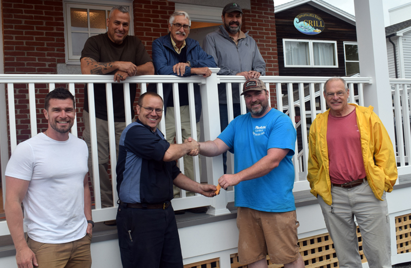 Robert Mattes, of Rockport-based Phi Builders + Architects, hands over the keys for the newly completed Damariscotta public restrooms to Damariscotta Board of Selectmen Chair Daryl Fraser on Friday, July 2. Front row, from left: Tom Mattes, of Phi Builders; Fraser; Robert Mattes; and Damariscotta Town Manager Matt Lutkus. Back row, from left: Charlie Frattini, of Phi Builders; architect George Parker; and Dan Phelps, of Damariscotta-based Phelps Architects. (Evan Houk photo)