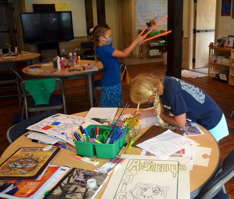 A camper designs a poster for the circus extravaganza during the Under the Big Top camp at the Merry Barn. (Nettie Hoagland photo)